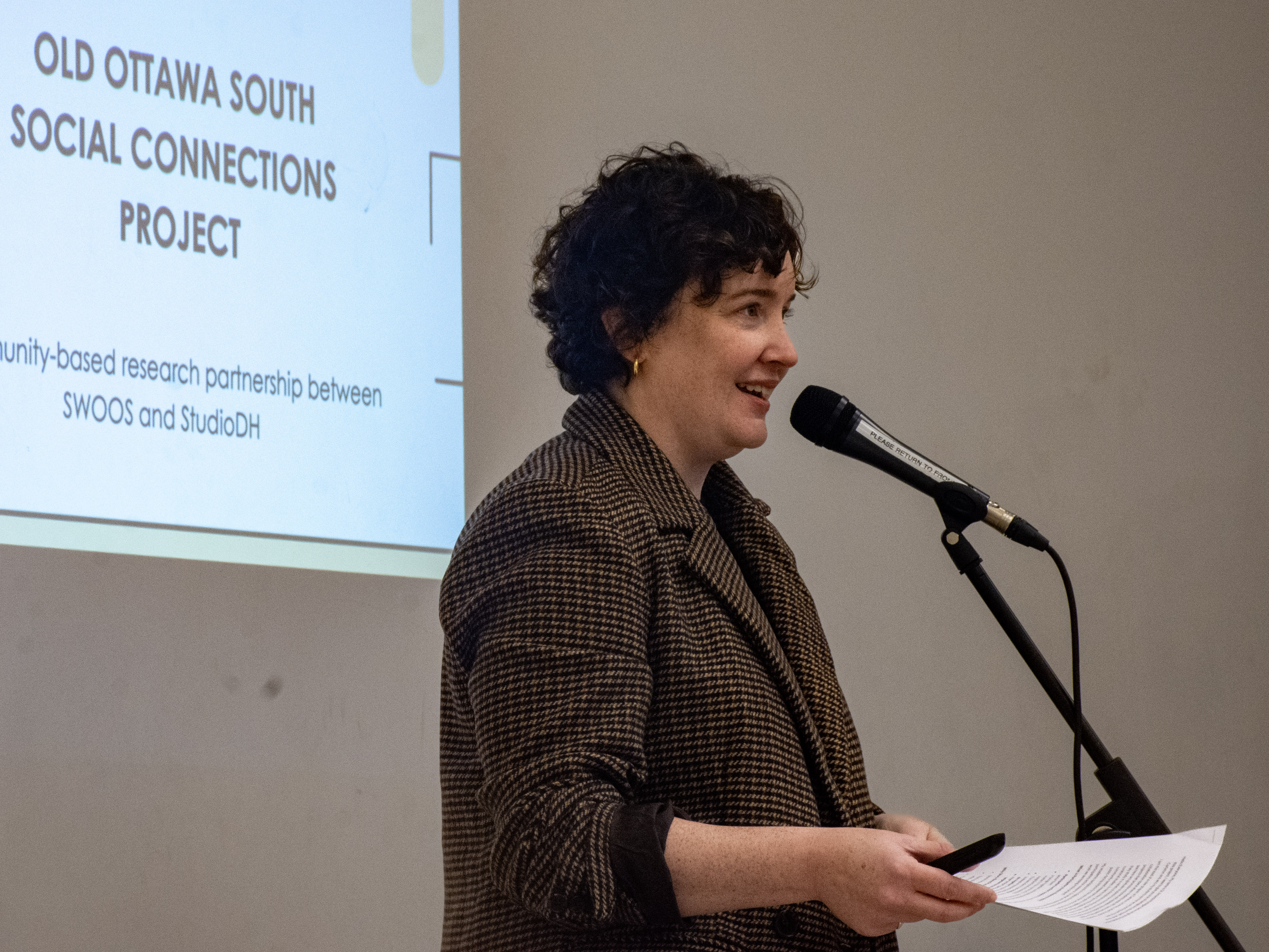 A woman presenting at a microphone