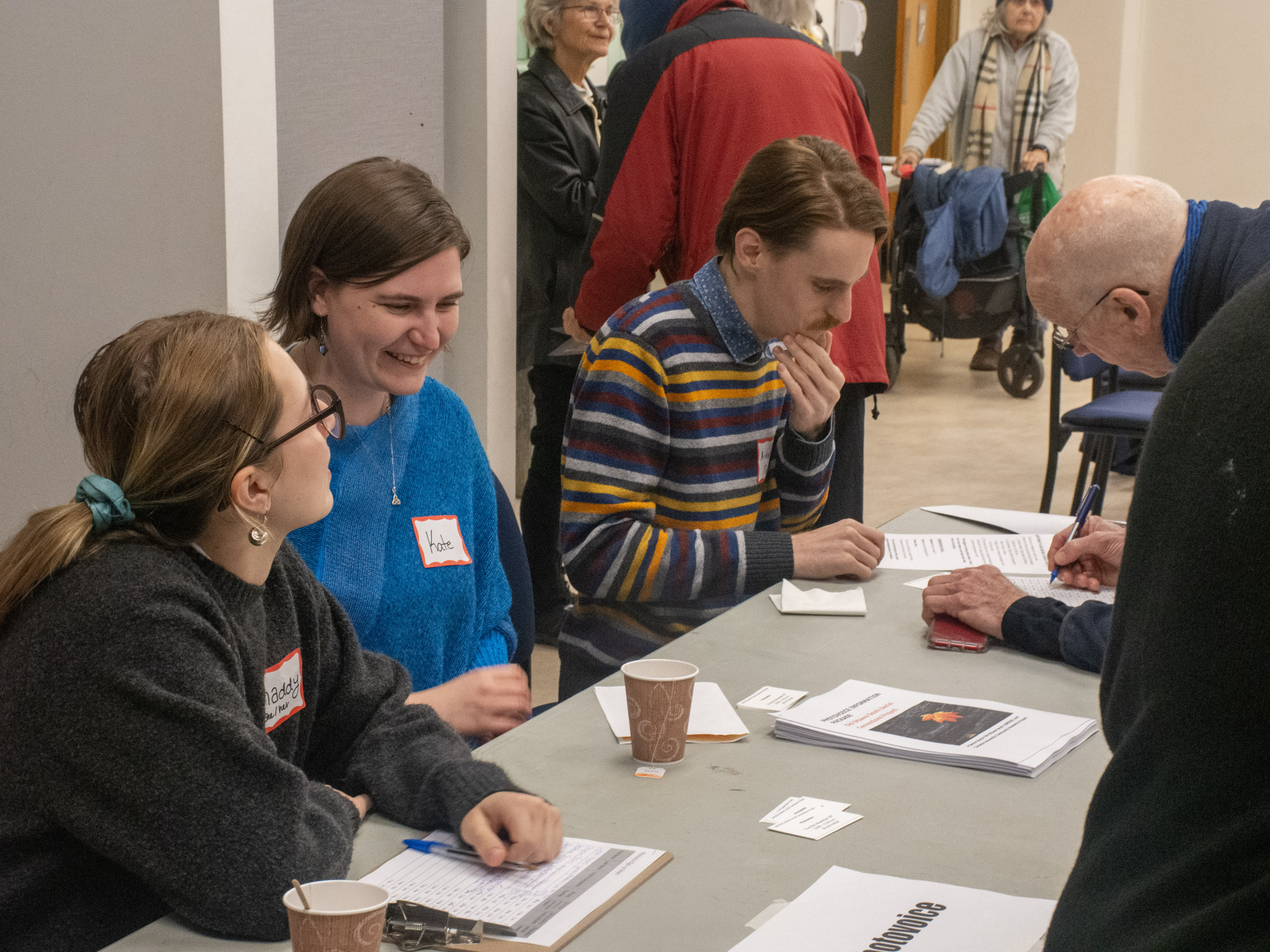 Three students registering a senior for a workshop